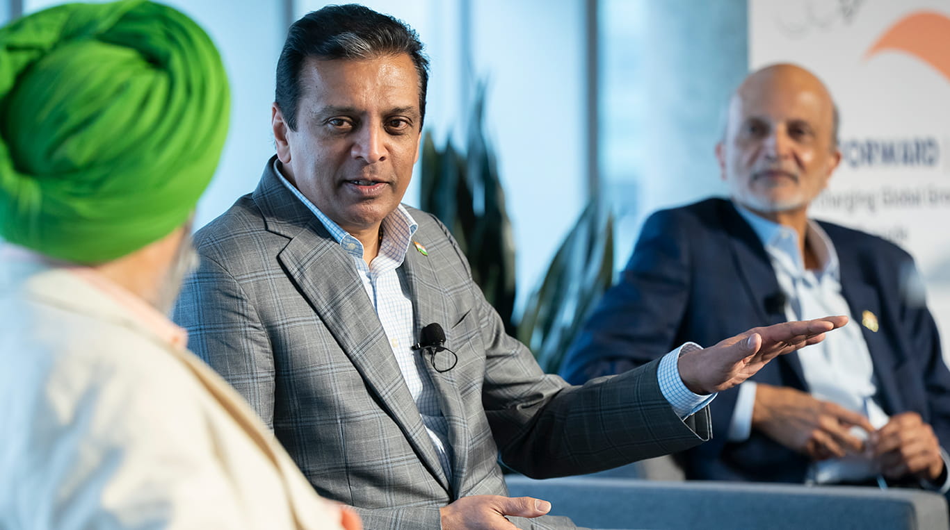 on the left, a man wearing a green turban and two other men (middle and right) in business suits