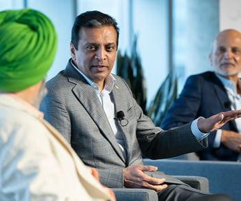  on the left, a man wearing a green turban and two other men (middle and right) in business suits