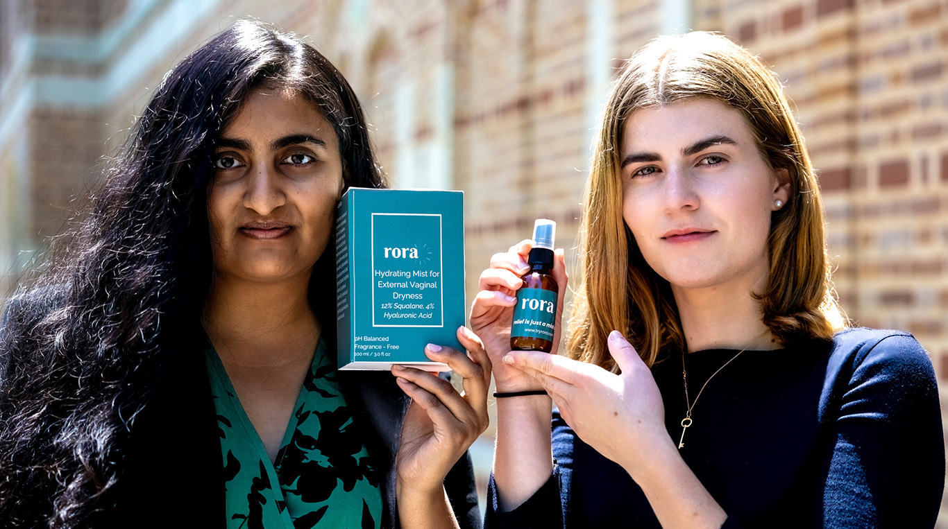 Two women each holding a product