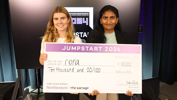 Two women holding a large check