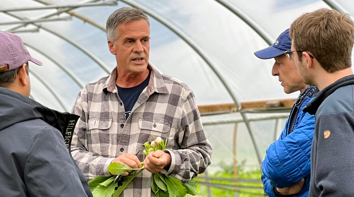 A man teaching MBA students about regen ag in a greenhouse