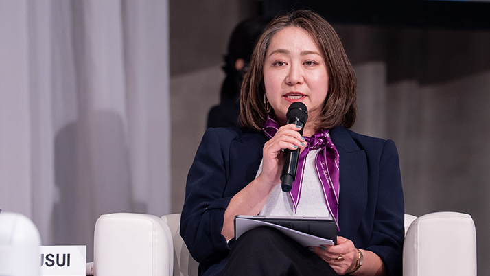 An Asian woman with a purple scarf tie around her neck