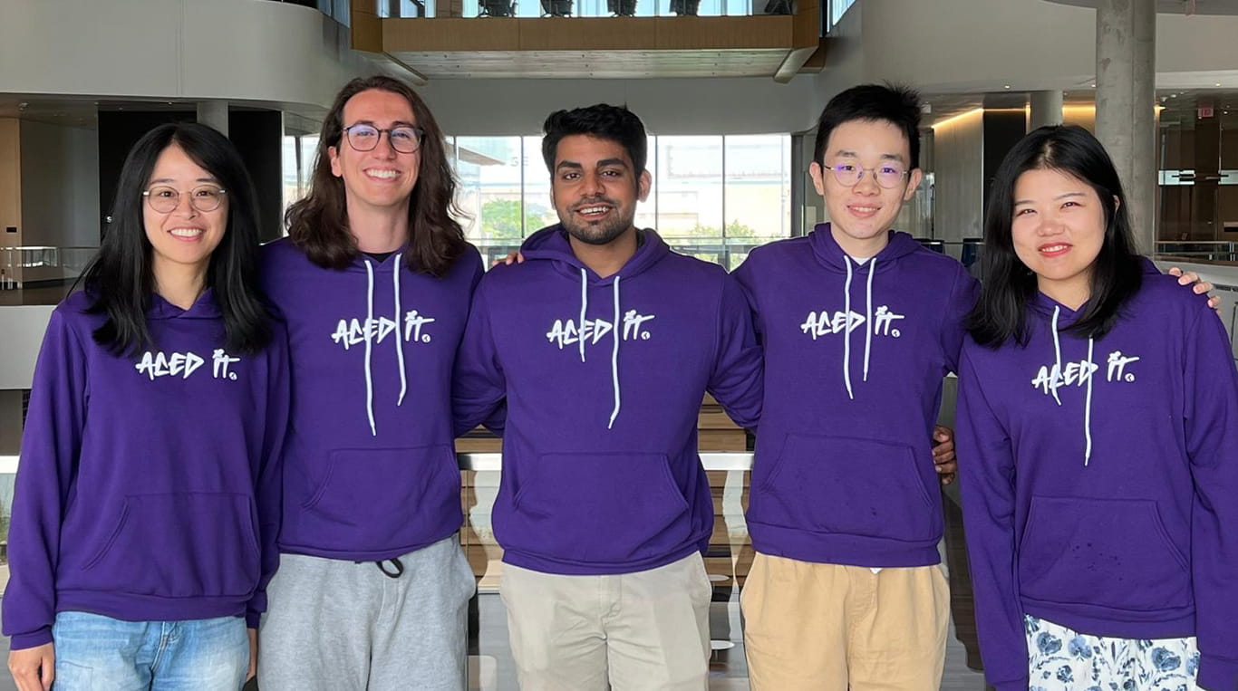 A group of Kellogg MBA students wearing purple hoodies at the Global Hub.