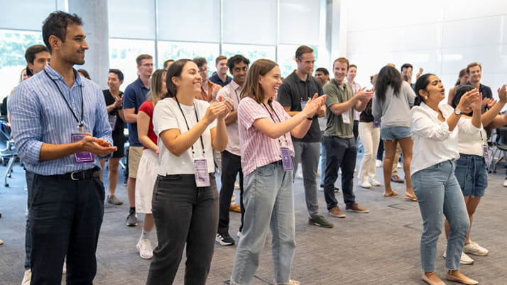 A group of business students applauding.