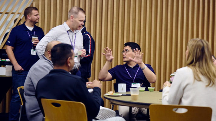 A group of Kellogg Executive MBA students talking with each other in a classroom
