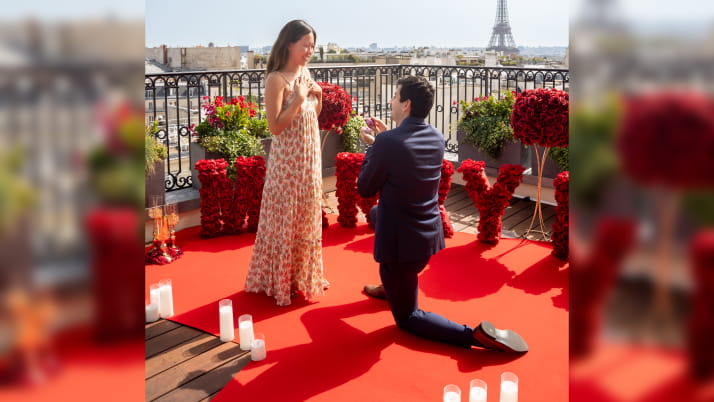 A man kneeling on one knee proposing to a woman