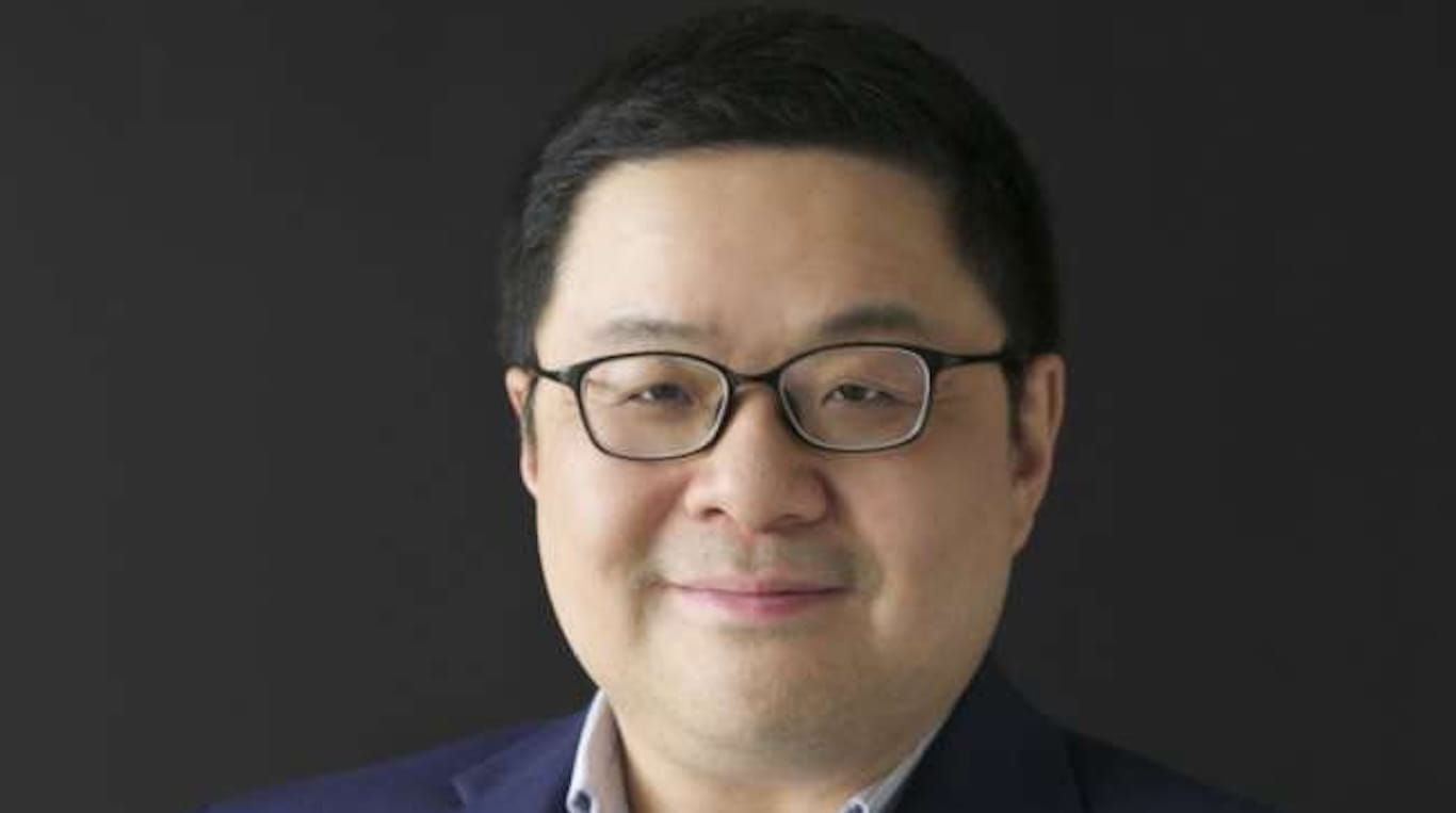 Asian man wearing glasses in a blazer and collared shirt