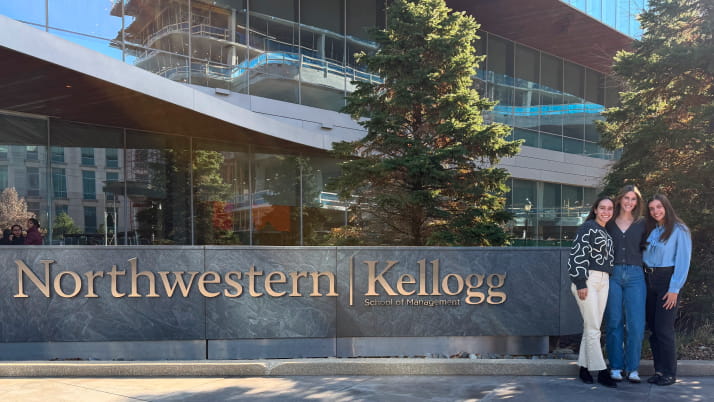 Three women standing in front of a building