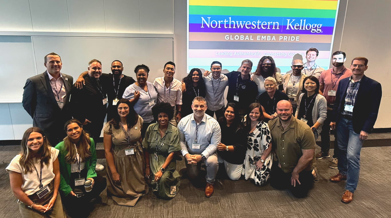 A group of smiling men and woman standing and kneeling in two rows 