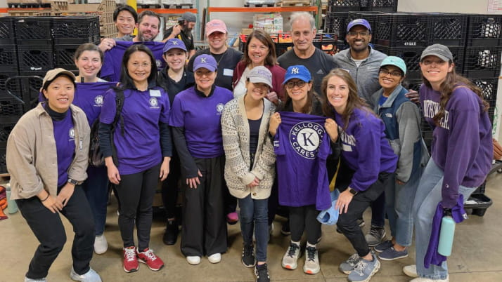 A group of men and women wearing purple shirts during a community service day
