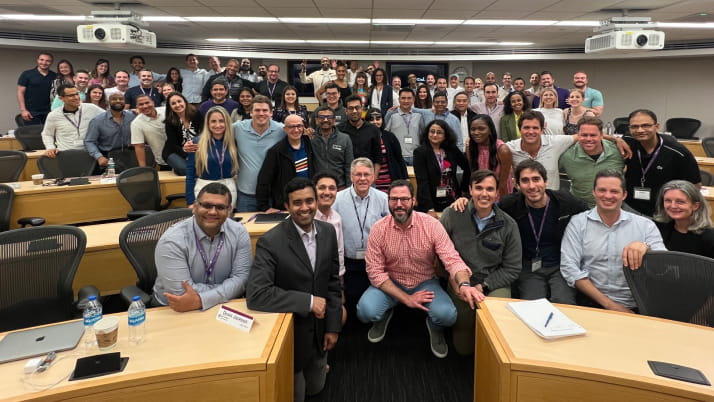A group of business school students huddled together in a classroom