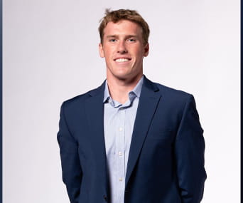 a light skinned man wearing blue blazer and a light blue dress shirt
