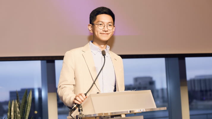 An MBA student standing behind a podium