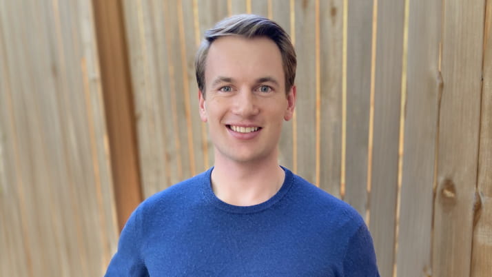 A white man wearing a blue sweater.