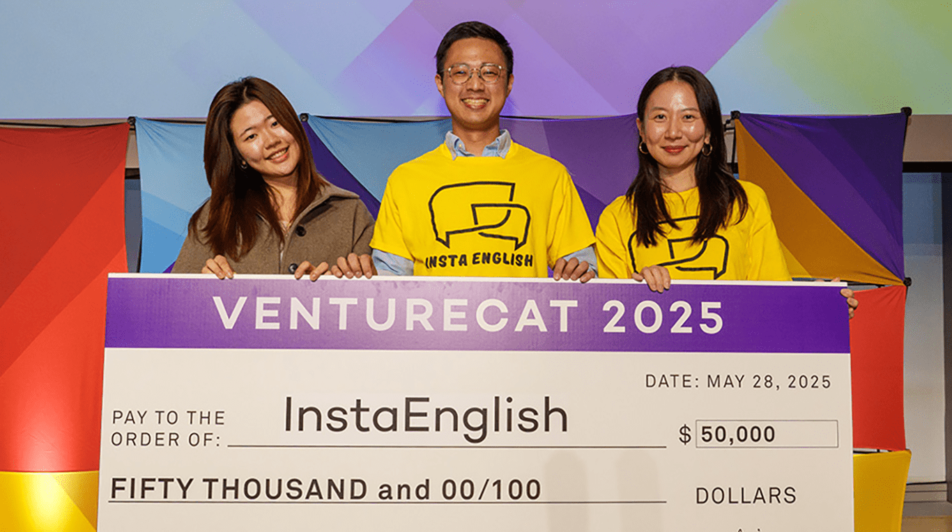 A man and two women on his left and right holding an oversized check